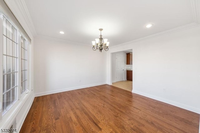 unfurnished room featuring a notable chandelier, ornamental molding, and light hardwood / wood-style floors