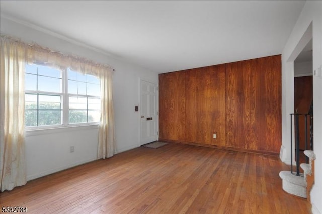 unfurnished living room with wood walls and wood-type flooring