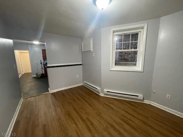 empty room featuring dark hardwood / wood-style flooring and a baseboard radiator