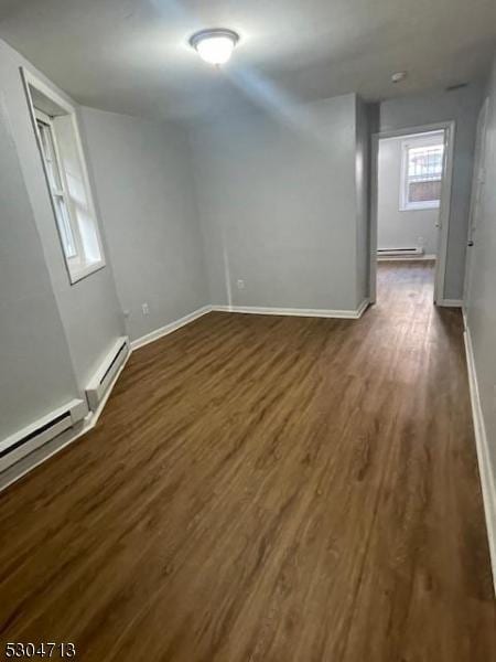 spare room with dark hardwood / wood-style flooring and a baseboard radiator