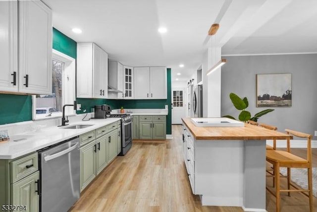 kitchen featuring appliances with stainless steel finishes, sink, green cabinetry, and white cabinetry