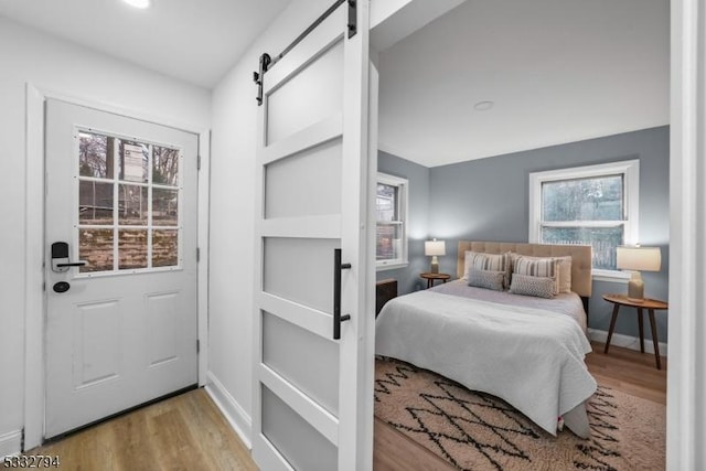 bedroom featuring a barn door and hardwood / wood-style floors