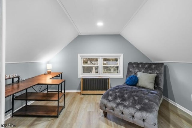 sitting room featuring radiator heating unit, lofted ceiling, and light hardwood / wood-style flooring