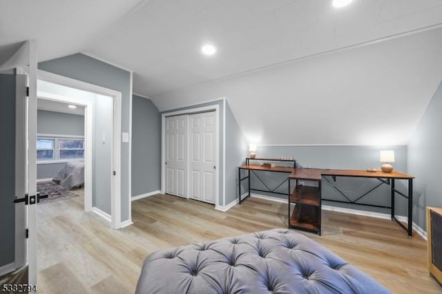 bedroom with a closet, vaulted ceiling, and light hardwood / wood-style floors