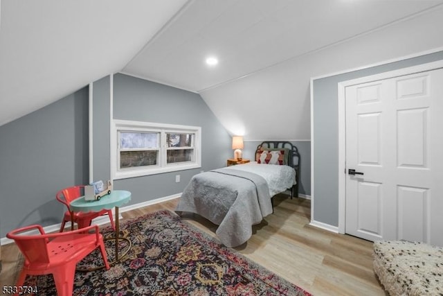 bedroom with vaulted ceiling and light wood-type flooring