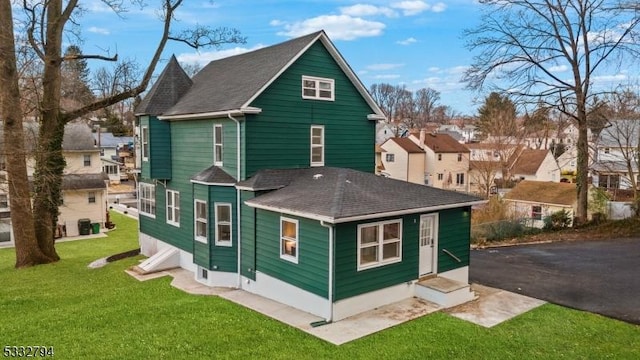 rear view of house featuring a lawn