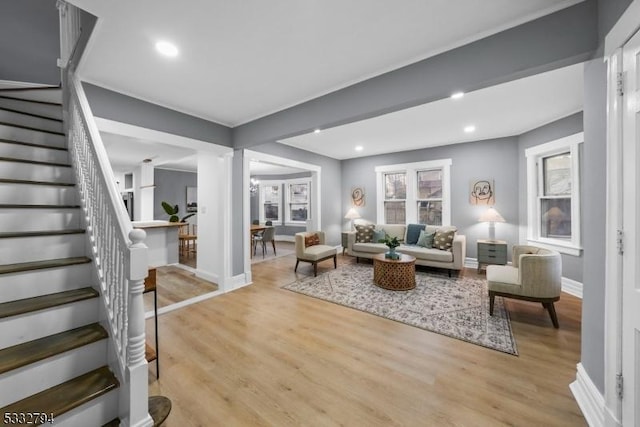 living room with ornate columns and light hardwood / wood-style flooring