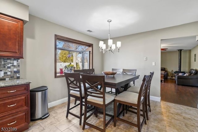 dining room with an inviting chandelier and a wood stove