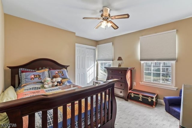 carpeted bedroom featuring a closet and ceiling fan