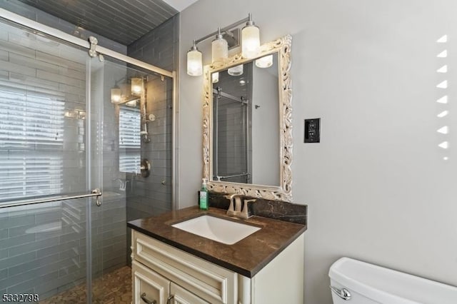 bathroom featuring toilet, walk in shower, and vanity