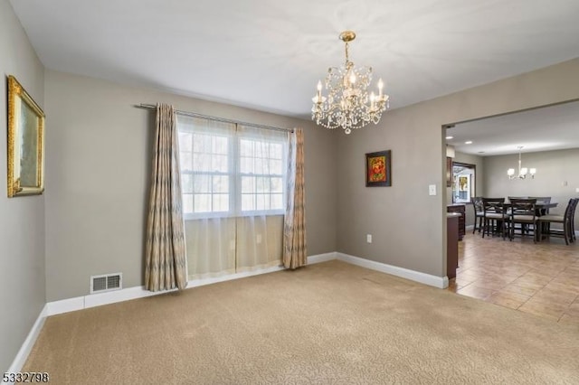 spare room featuring an inviting chandelier and carpet floors