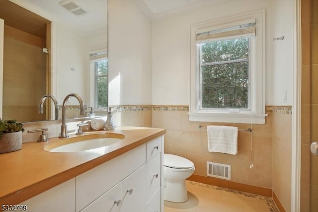 bathroom featuring vanity, toilet, tile patterned flooring, and tile walls