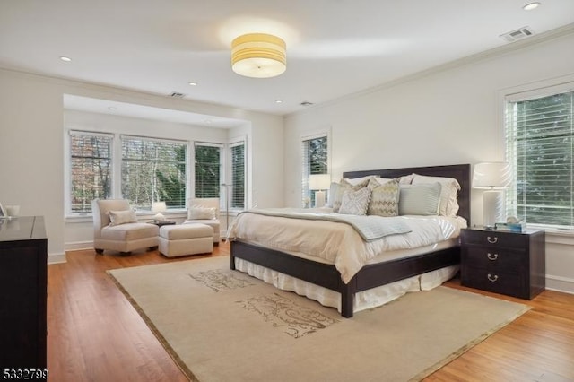 bedroom with multiple windows and hardwood / wood-style floors