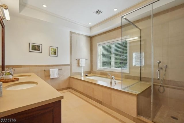 bathroom with a raised ceiling, shower with separate bathtub, crown molding, and vanity