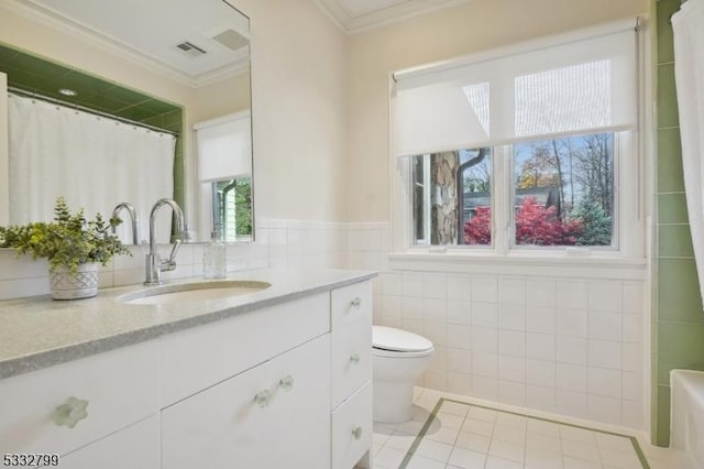 bathroom featuring toilet, tile walls, tile patterned floors, ornamental molding, and vanity