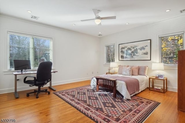 bedroom with hardwood / wood-style flooring, ceiling fan, and ornamental molding