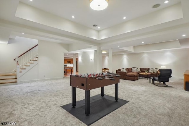 recreation room with a tray ceiling and carpet flooring