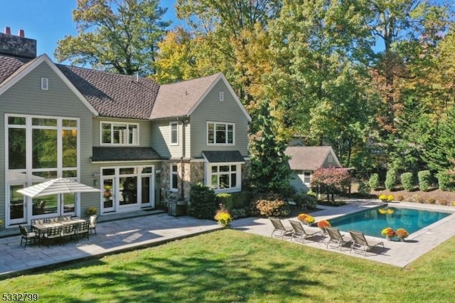 rear view of house featuring french doors, a patio area, and a yard