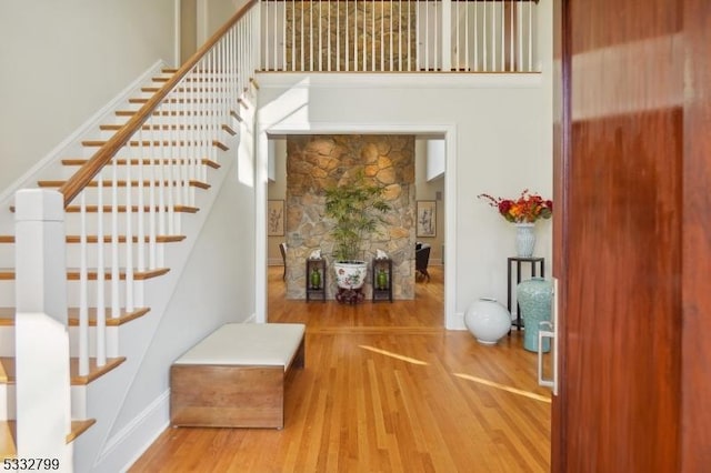 stairway featuring a towering ceiling and hardwood / wood-style flooring