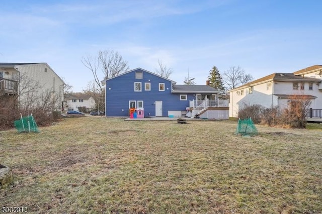 rear view of property with a deck and a lawn