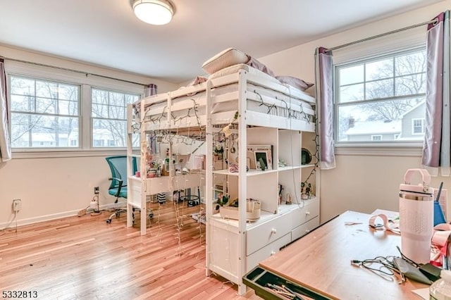 bedroom with light wood-type flooring and multiple windows