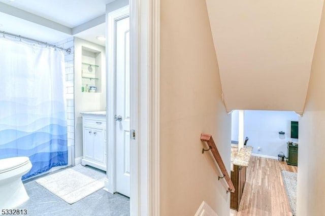 bathroom with toilet, hardwood / wood-style floors, and curtained shower