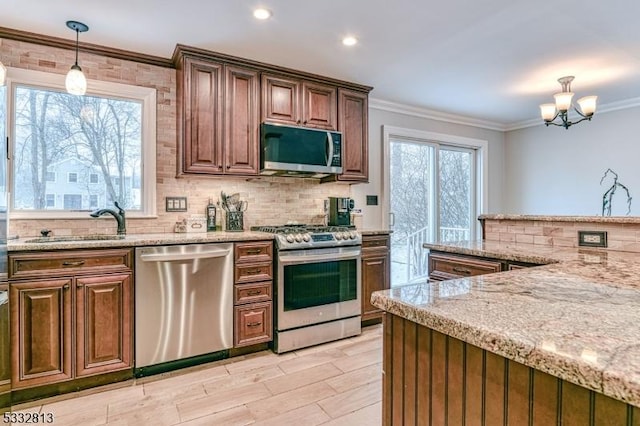 kitchen featuring decorative light fixtures, appliances with stainless steel finishes, ornamental molding, and a chandelier