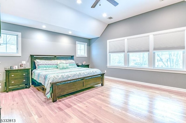 bedroom with ceiling fan, light hardwood / wood-style flooring, and vaulted ceiling