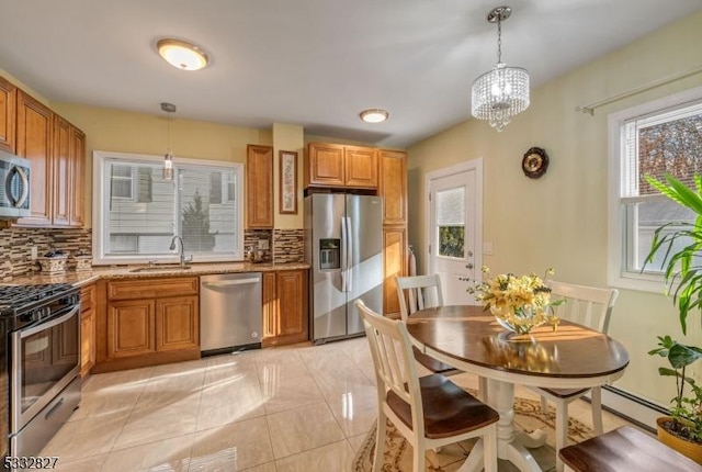 kitchen featuring hanging light fixtures, backsplash, and stainless steel appliances