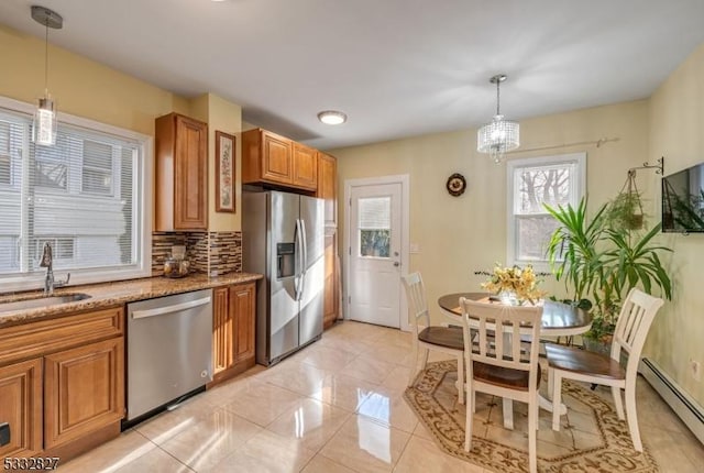 kitchen featuring a baseboard heating unit, stainless steel appliances, decorative backsplash, pendant lighting, and sink