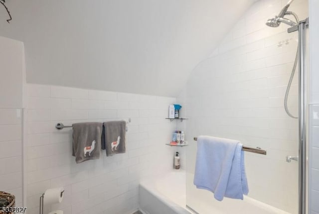 bathroom featuring a tile shower and lofted ceiling