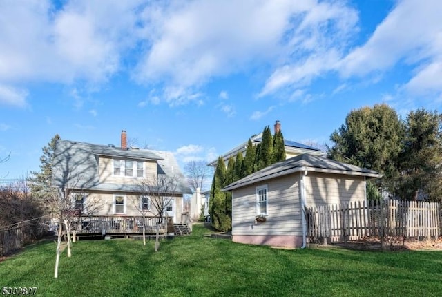 back of house with a lawn and a wooden deck