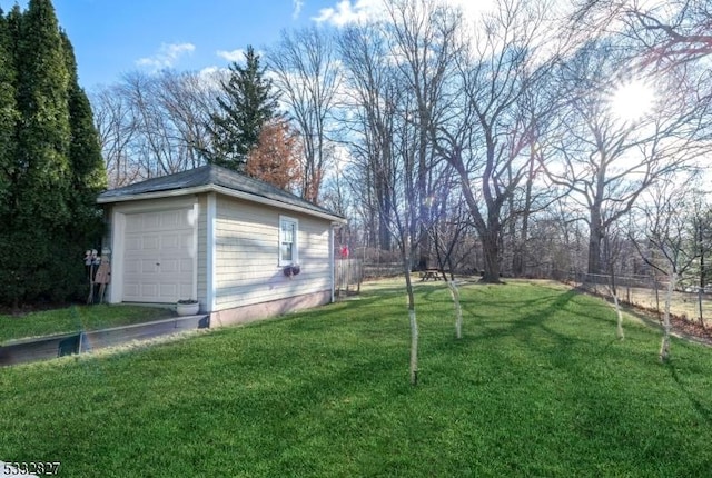 view of yard with a garage and an outbuilding