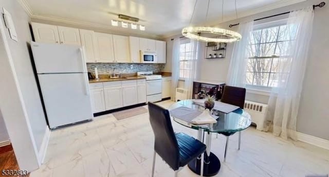 kitchen with white cabinets, white appliances, and radiator