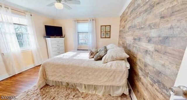 bedroom featuring multiple windows, ceiling fan, and hardwood / wood-style floors