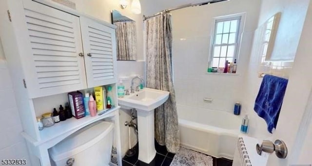 full bathroom with tile patterned floors, sink, shower / tub combo with curtain, and toilet