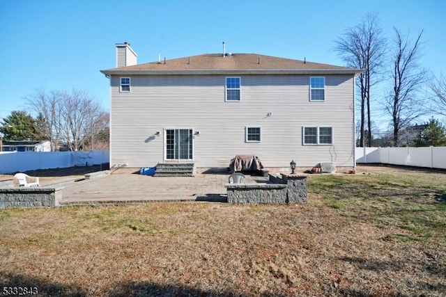 rear view of house featuring a patio, an outdoor fire pit, and a yard