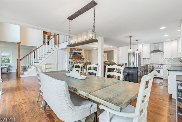 dining area with hardwood / wood-style flooring and a stone fireplace