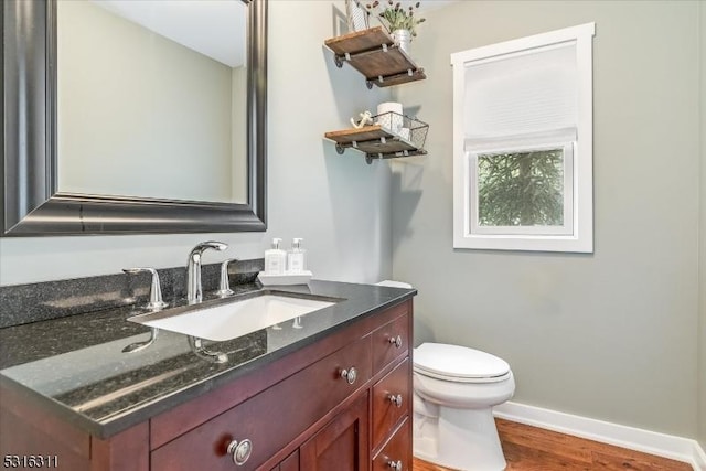 bathroom featuring toilet, wood-type flooring, and vanity