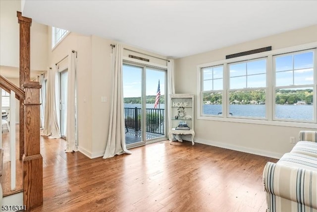 unfurnished room featuring wood-type flooring and a water view