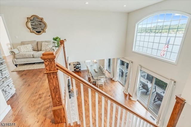 stairway with a high ceiling and wood-type flooring