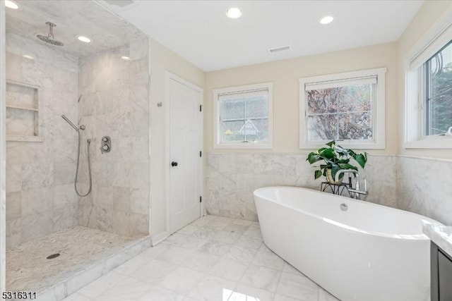 bathroom featuring tile walls, separate shower and tub, vanity, and plenty of natural light