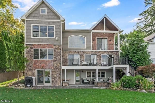 back of property featuring a balcony, a yard, and a patio area