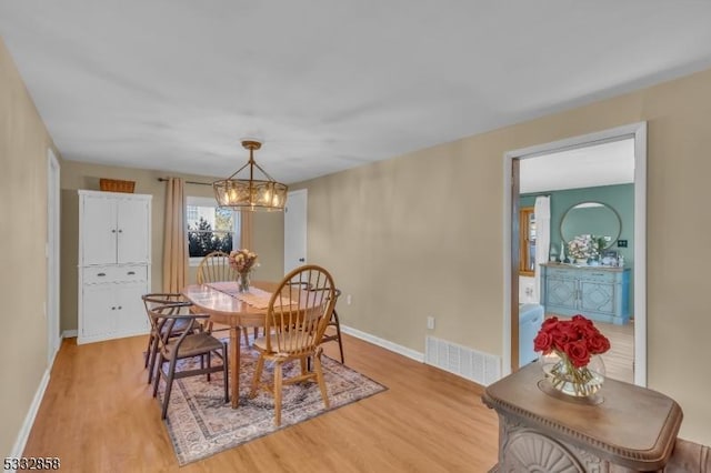 dining area featuring a chandelier and light wood-type flooring