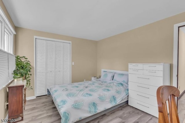 bedroom featuring light wood-type flooring and a closet