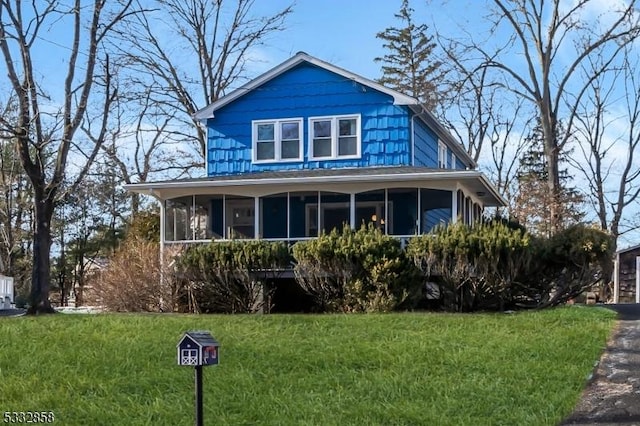 view of front of home featuring a front yard and a sunroom