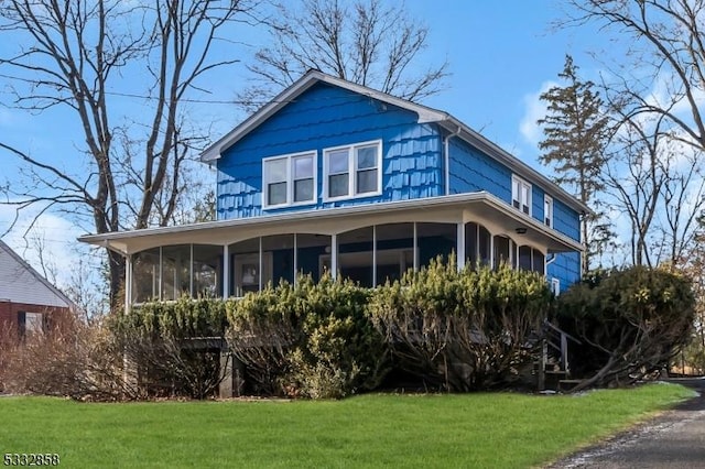 view of home's exterior featuring a yard and a sunroom