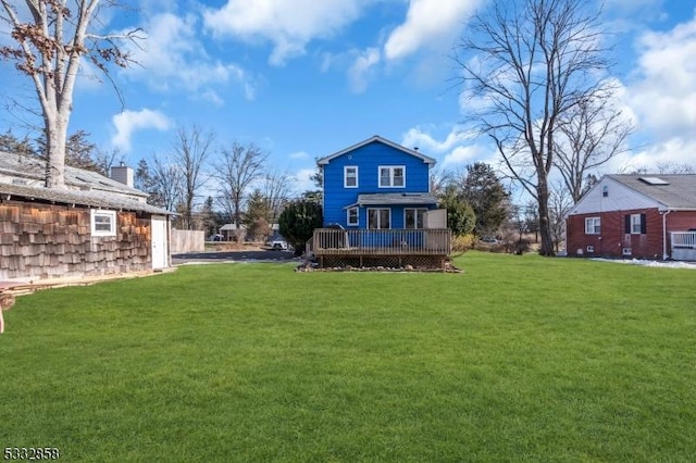 back of house with a lawn and a wooden deck