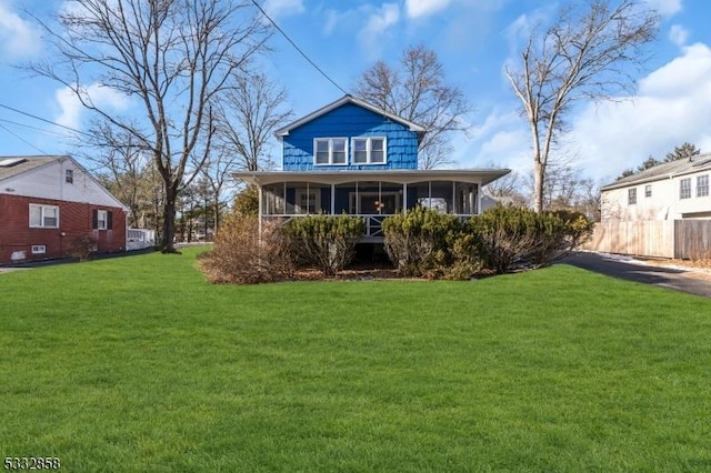 back of property featuring a lawn and a sunroom