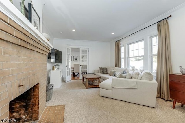 living room with a brick fireplace, crown molding, and carpet flooring